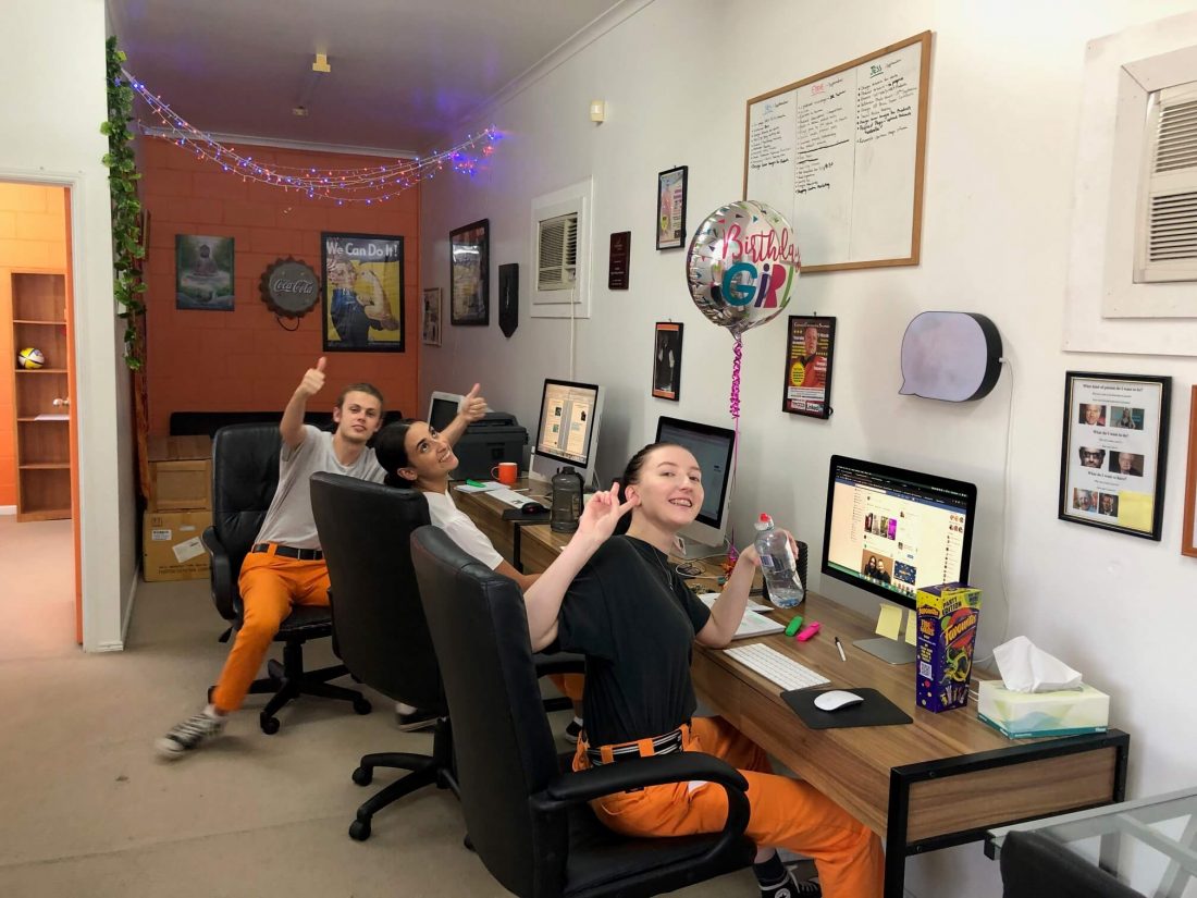  Image of Jessie, Yasmin and Dylan at work sitting at desks waving at camera at Creative Copywriting & Content Solutions Gold Coast