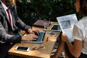 Image of man and woman sitting at table reading newspaper on Copywriting & Marketing Jargon blog page at Creative Copywriting & Content Solutions website