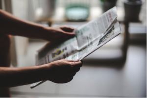 Image of two arms holding up newspaper on blog at Creative Copywriting & Content Solutions