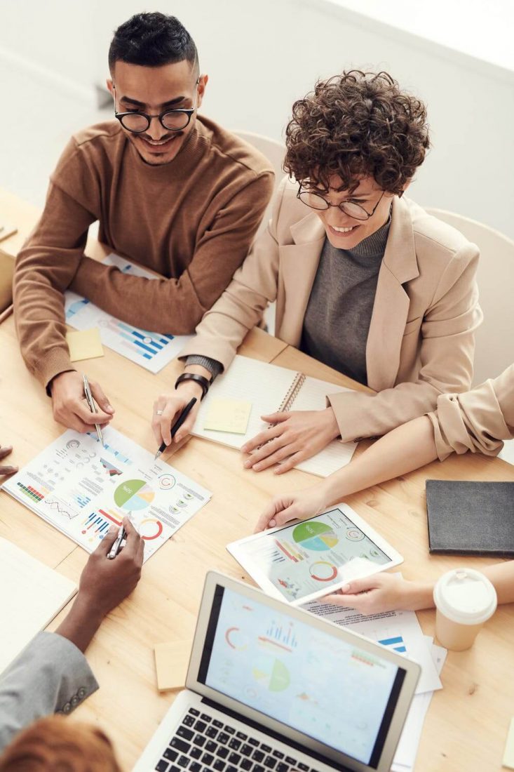 Image Of Black & White Woman Sitting At Desk Looking At Pie Chart - Copywriting Courses Online VS Offline Blog Creative Copywriting & Content Solutions